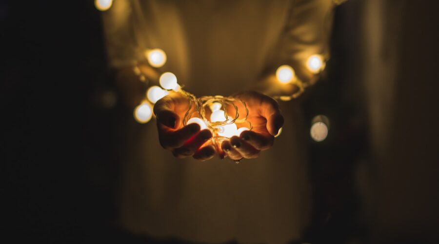 person holding string lights