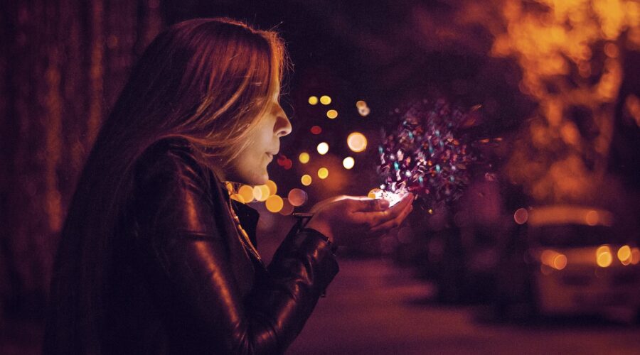 woman blowing sprinkle in her hand