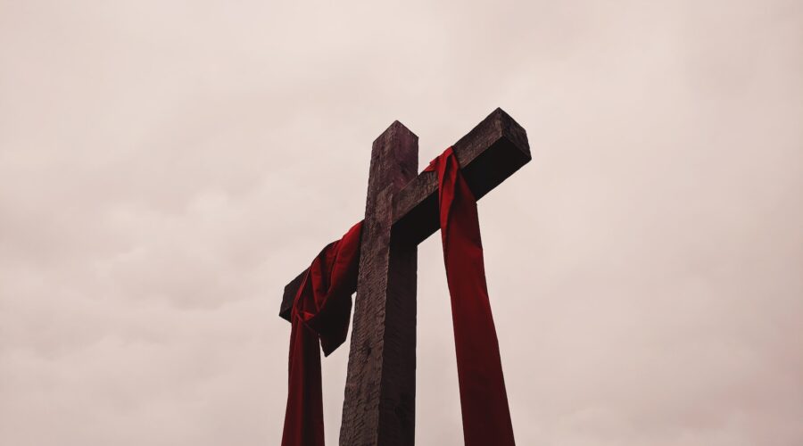 low angle view of cross with red garment