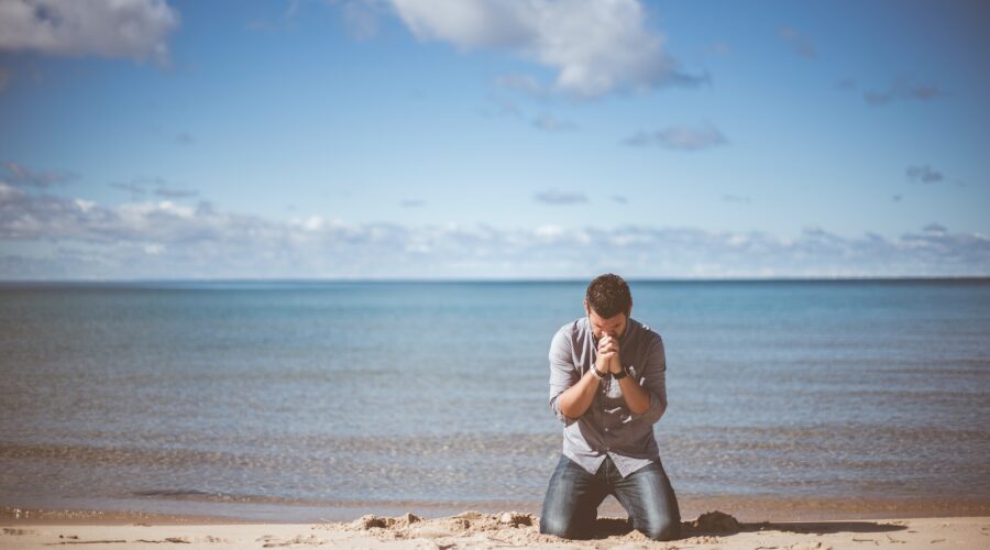 man kneeling down near shore