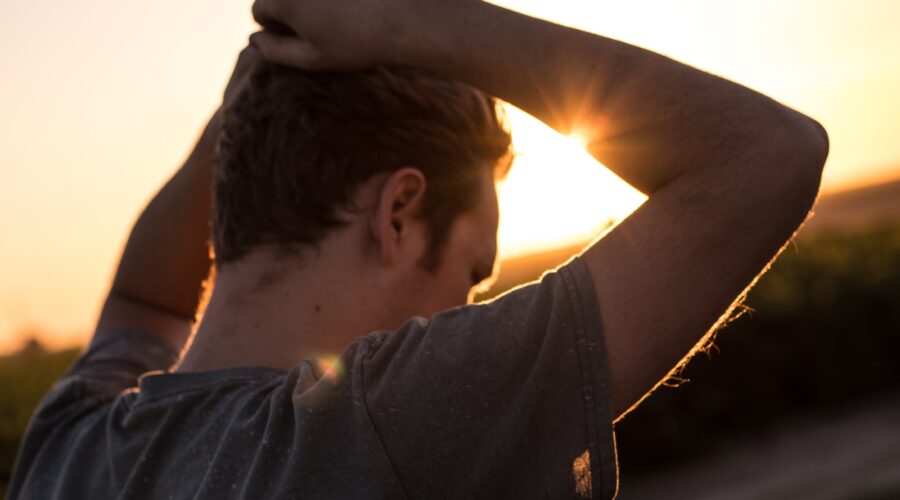 man holding his hair against sunlight