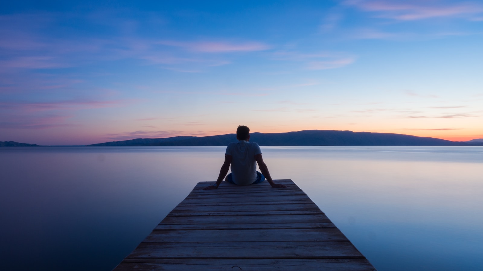 man siting on wooden dock