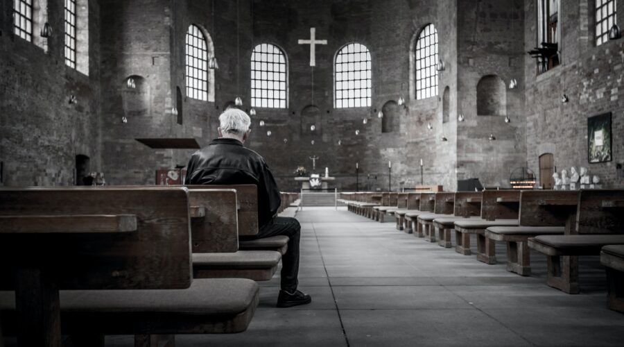 person sitting on pew inside church