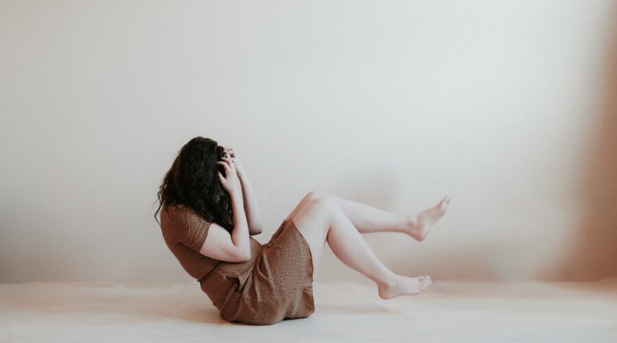 woman sitting on floor wearing brown dress