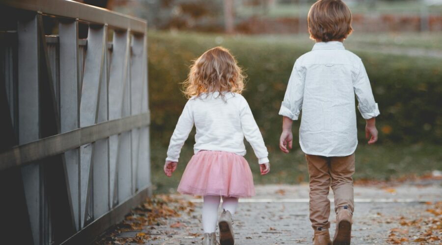 boy beside girl walking near railing