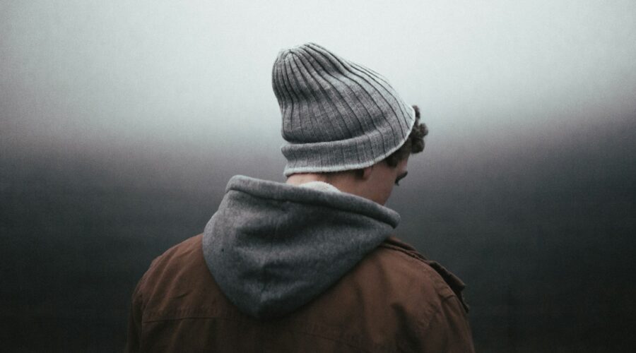 man wearing knit cap on grey background