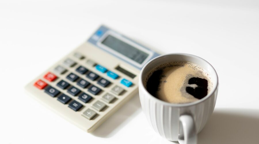 a cup of coffee next to a calculator