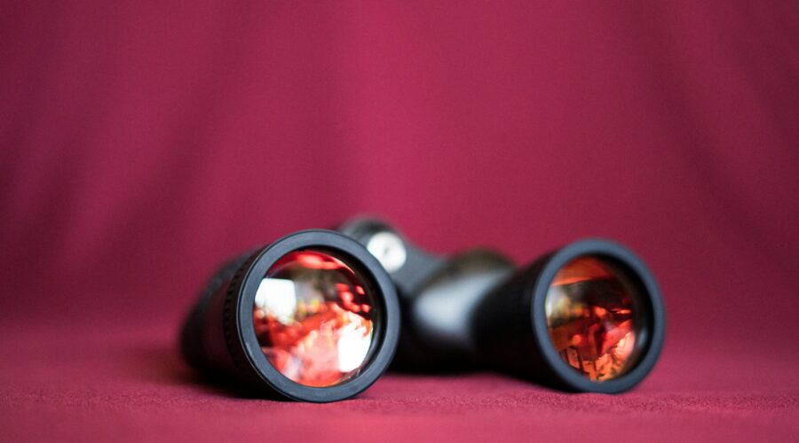 a pair of binoculars sitting on top of a red cloth