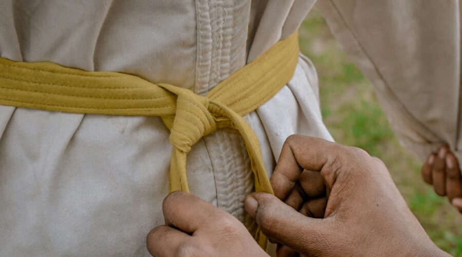 a person tying a belt around another person's waist