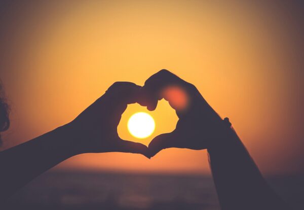 silhouette of person's hands forming heart