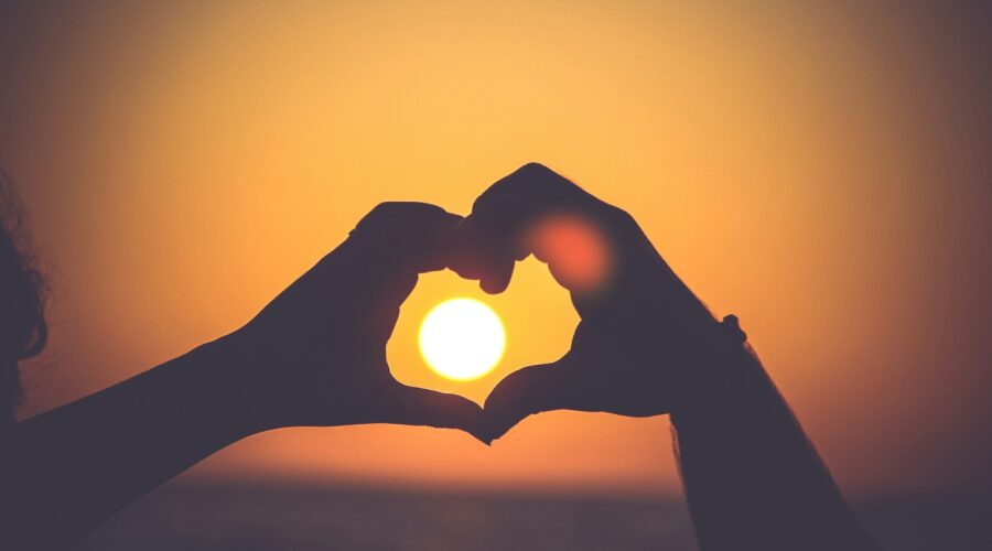 silhouette of person's hands forming heart