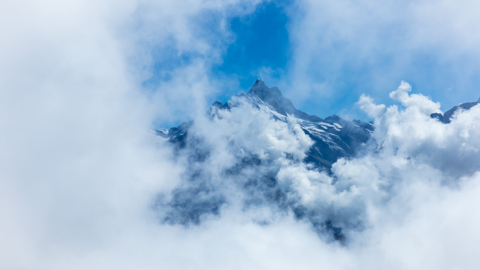 a view of a mountain covered in clouds