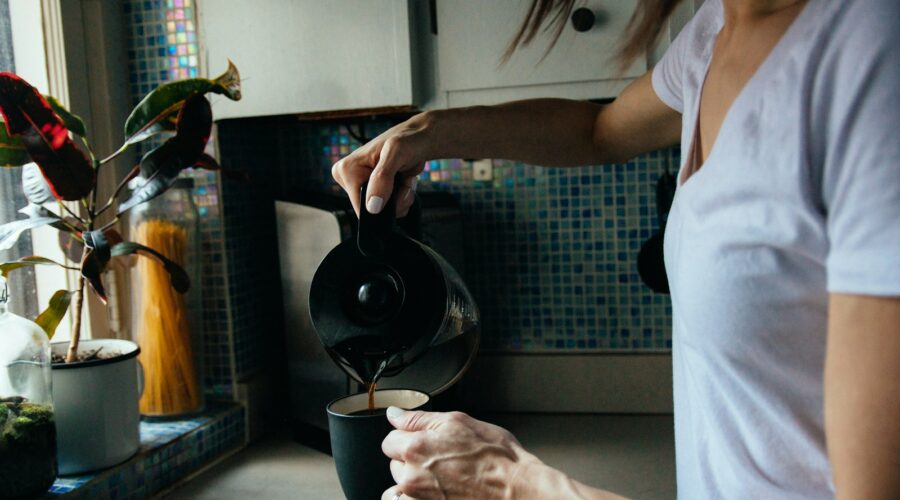 woman in white t-shirt holding black ceramic mug