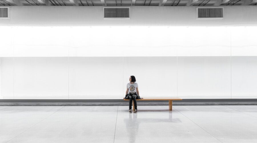 a woman sitting on a bench in a large room